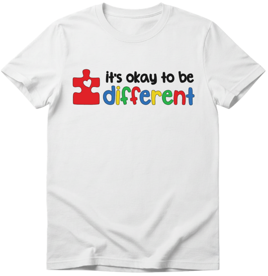White t-shirt with colorful text 'It's okay to be different' featuring a puzzle piece design on a white T-Shirt
